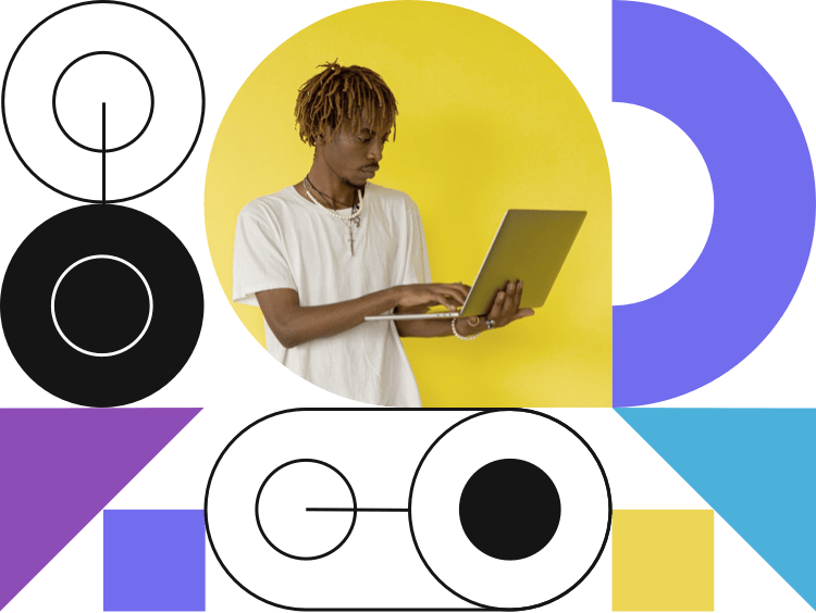 Young, african-american man holding laptop computer while typing on it