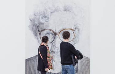 Two visitors view Old Woman Wearing Glasses, a charcoal and oil on canvas by artist A.A. RP.